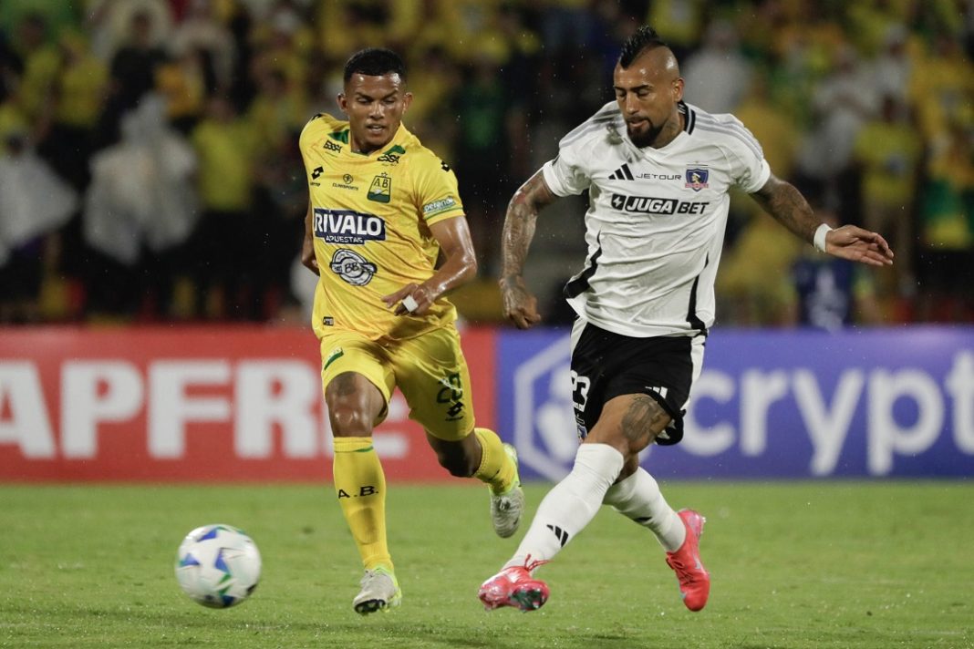 Jugador de Bucaramanga y Arturo Vidal disputando el balón.